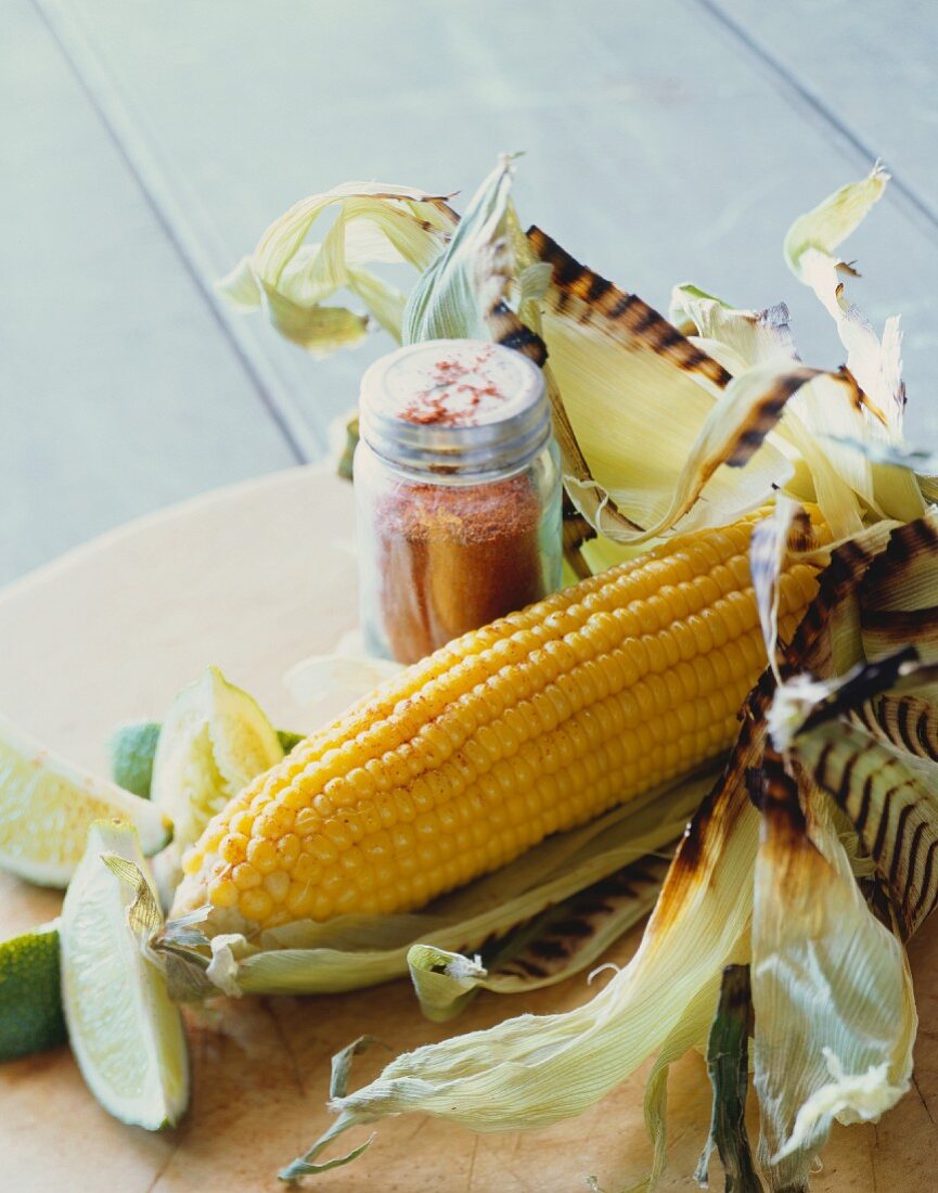 Gegrillter Maiskolben mit Limettenschnitze und Paprikapulver