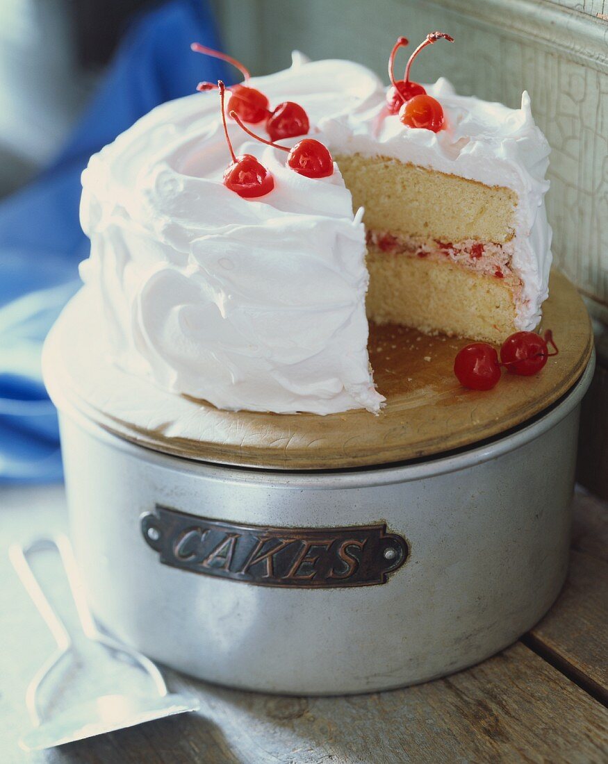 Layered Cherry Cake with White Frosting; Slice Removed