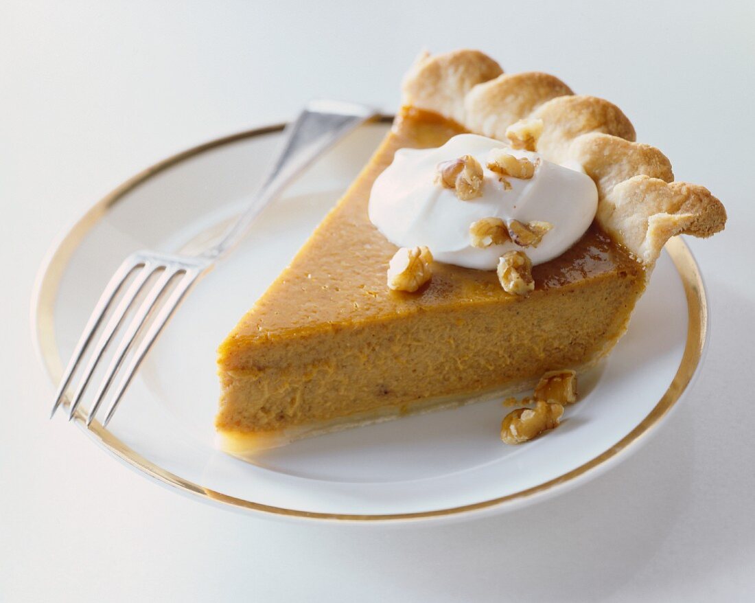Slice of Pumpkin Pie with Whipped Cream and Chopped Walnuts