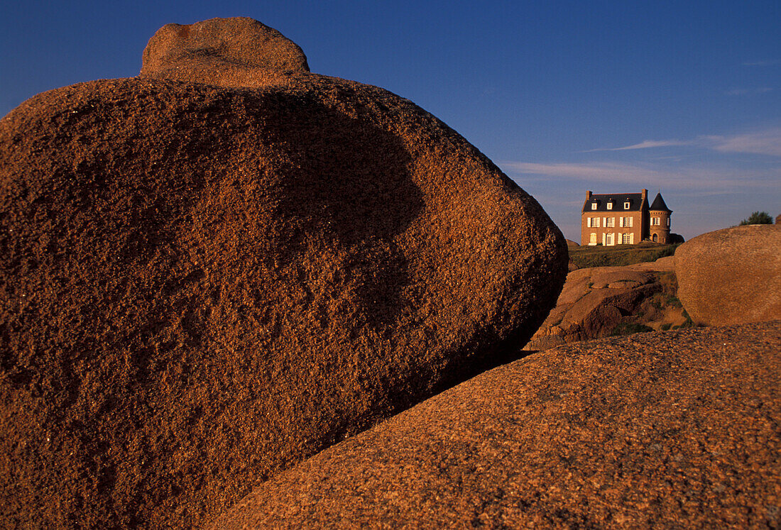 House on limestone boulders in the sunlight, Cote de Granit Rose, Brittany, France, Europe