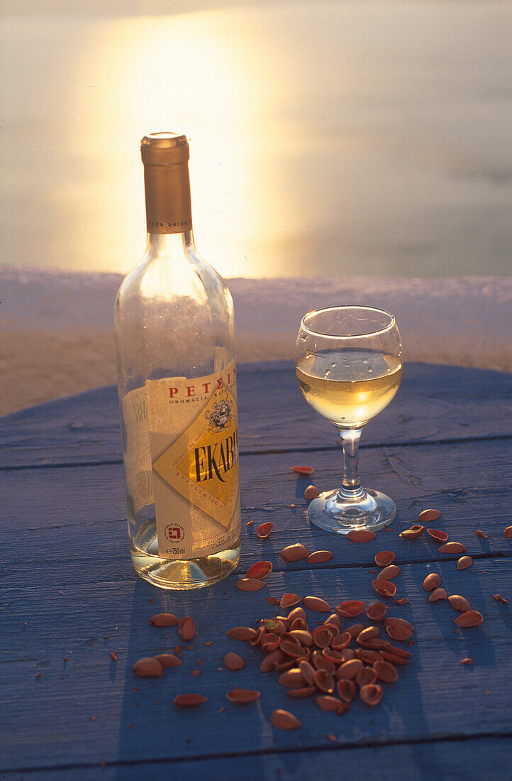 Weinflasche und Weinglas im Abendlicht, Santorin, Griechenland, Europa