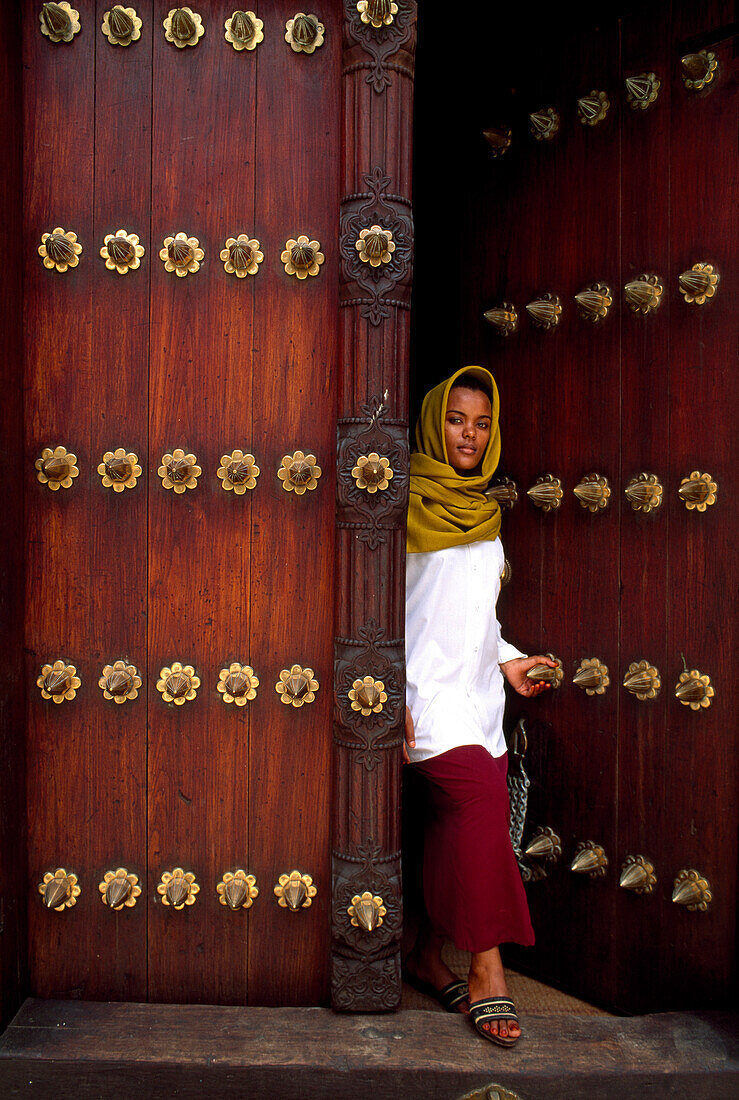 African woman going through a door, Zanzibar, Tansania, Africa