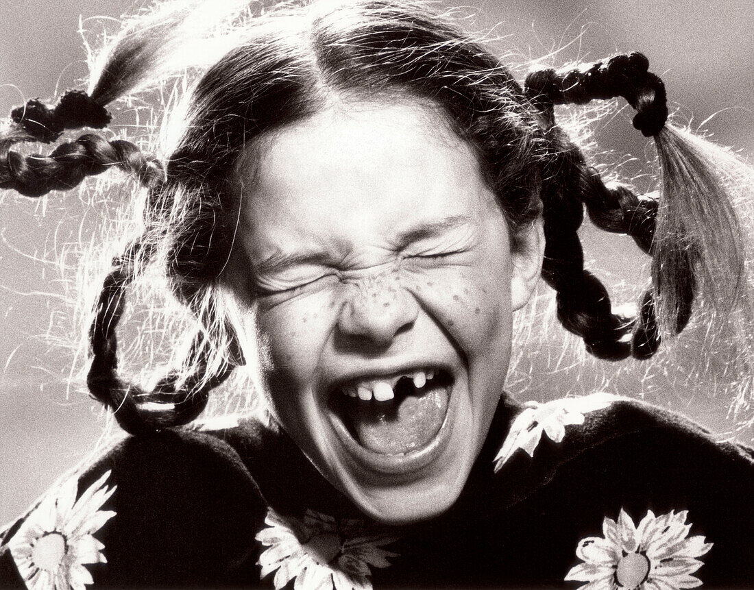 Screaming girl with missing front teeth, portrait