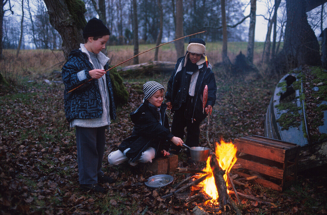 Kinder kochen am Lagerfeuer