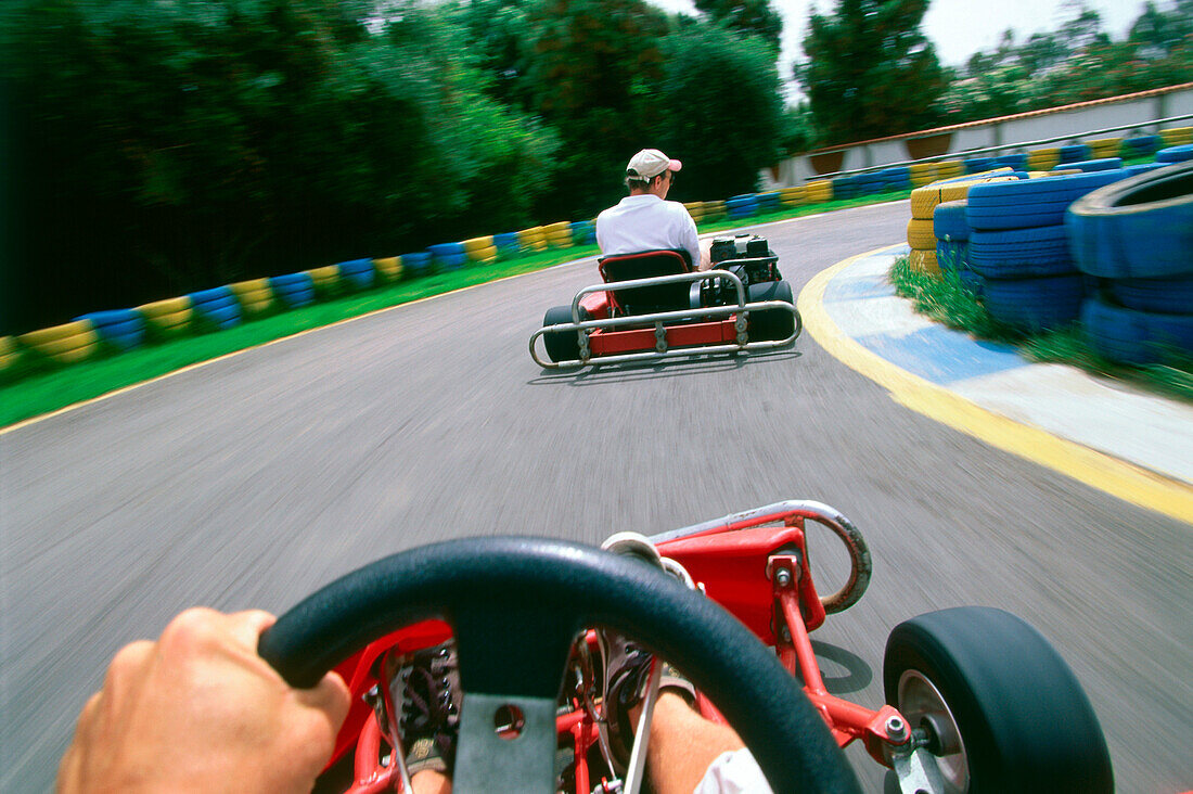 Men go-cart racing, rear view