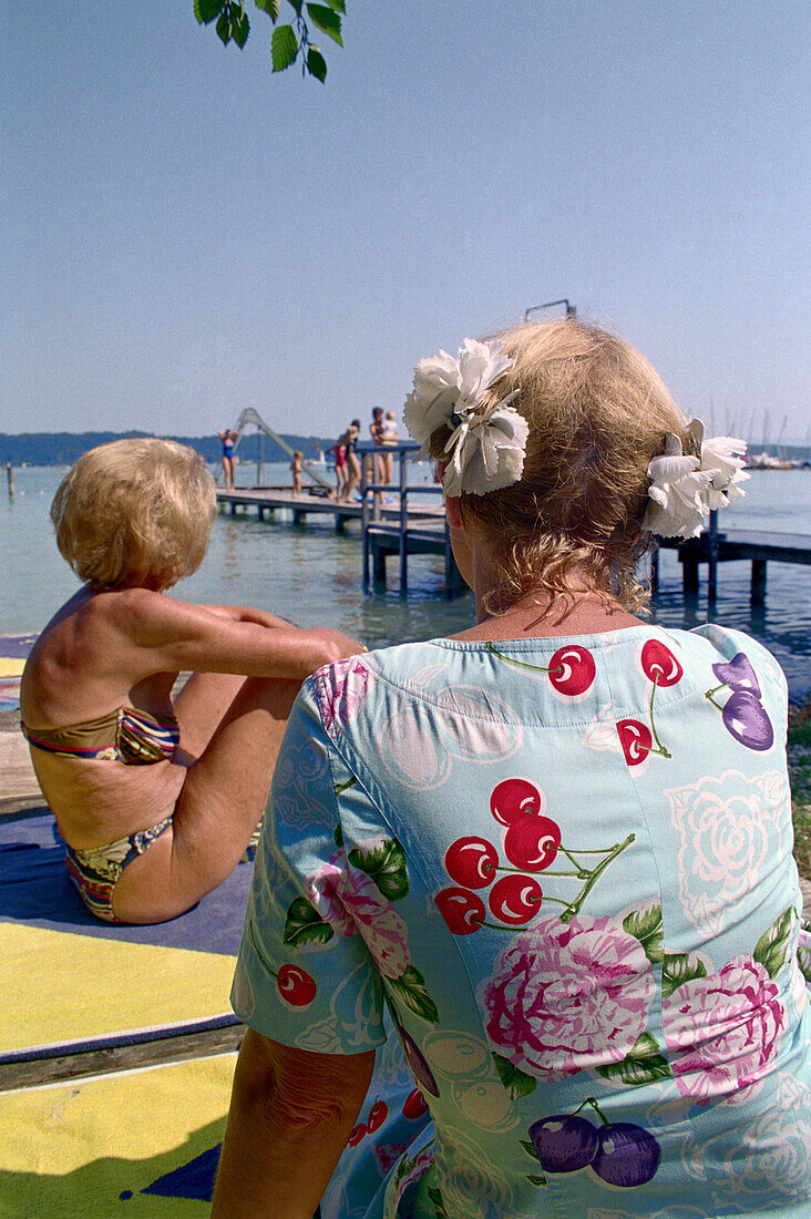 Older women sitting at lake, Starnberger See, Bavaria, Germany