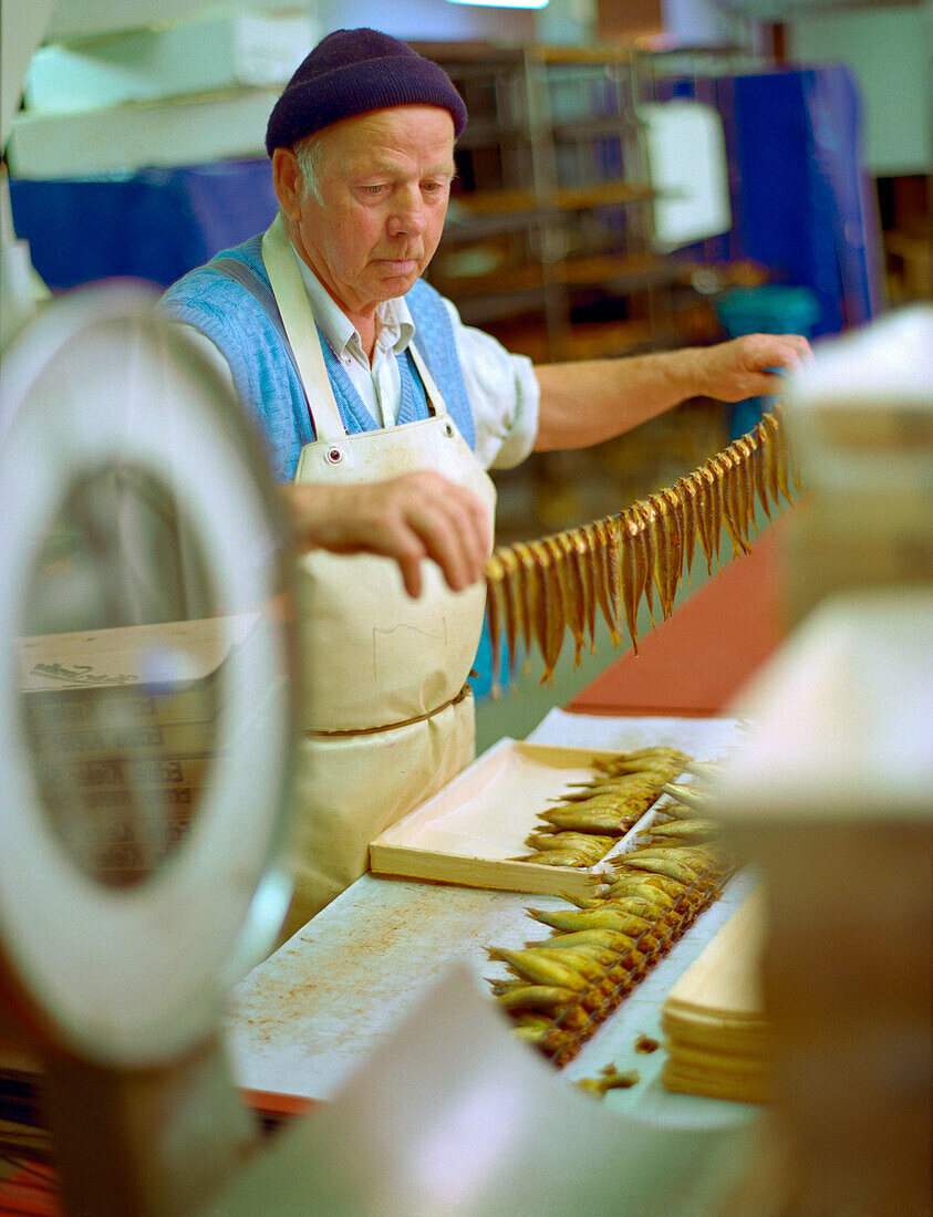 Man preparing Kieler Sprotten speciality, Smokehouse Foeh, Kappel, Schleswig-Holstein, Germany