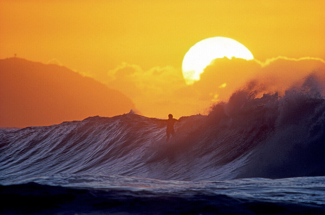 Surfing in the sunset, Hawaii, USA
