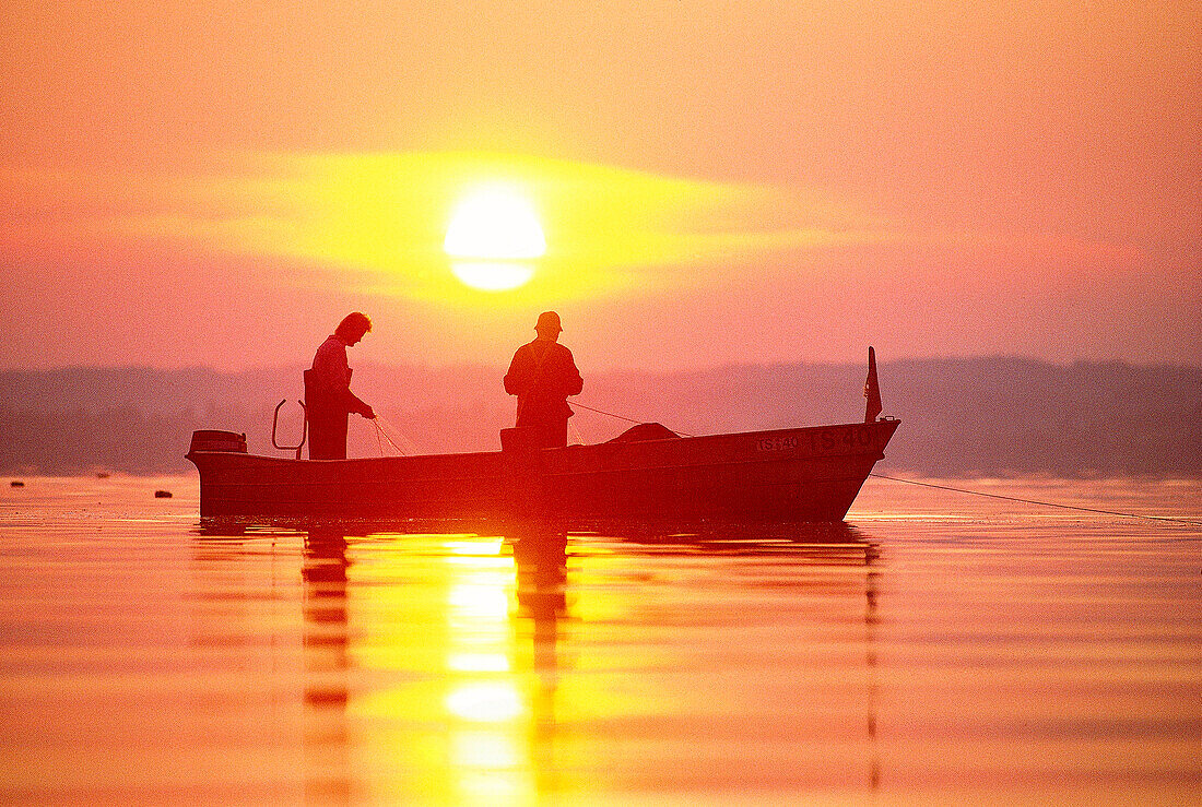 Two men fishing at lake Chiemsee, Upper Bavaria, Germany