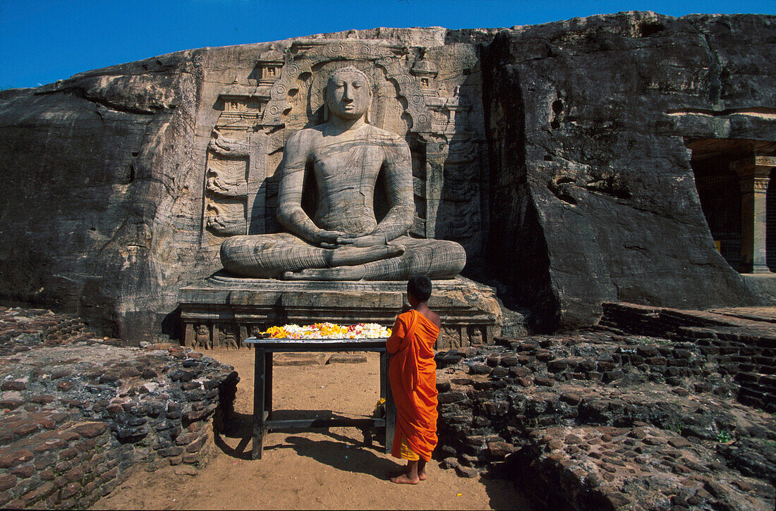Young monk in front of rock temple Gal Vihara, Polonnaruwa, Sri Lanka, Asia
