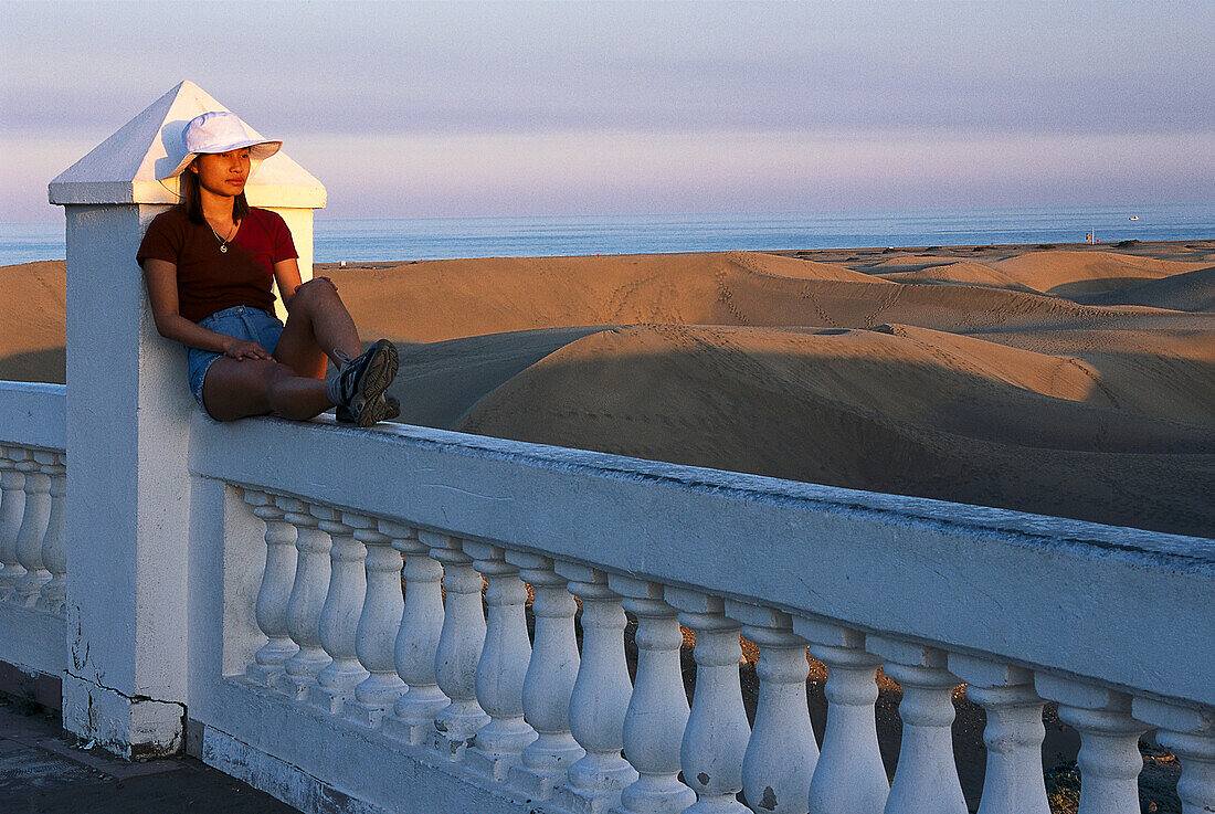 Frau geniesst den Abendsonne an der Brüstung von Hotel Riu Palace, Playa del Ingles, Gran Canaria, Kanarische Inseln, Spanien