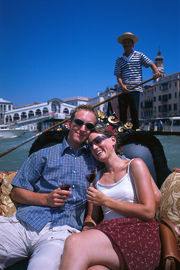 Young couple sitting in a gondola, Ponte de Rialto, Canale Grande, Venice, Italy
