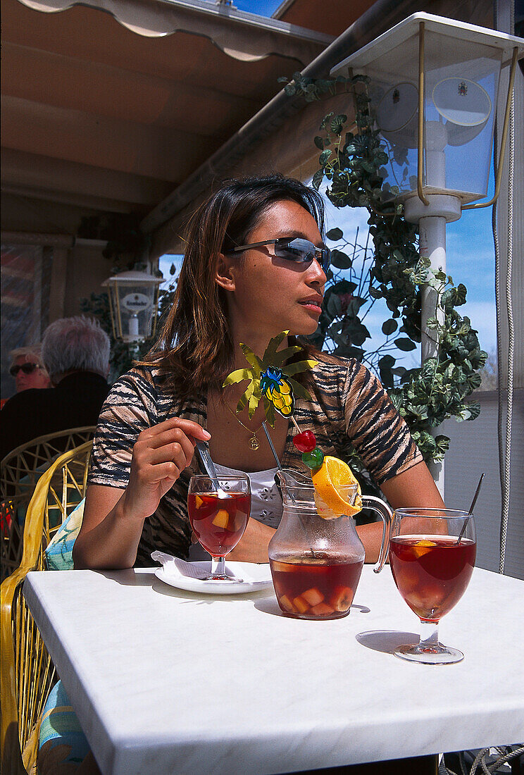 Frau geniesst ein Cocktail, Playa del Ingles, Gran Canaria, Kanarische Inseln, Spanien