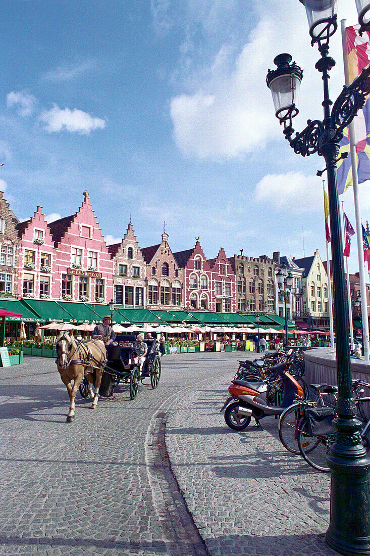 Horse-drawn carriage, cafes and gabled houses under clouded sky, Grote Market, Bruges, Belgium, Europe