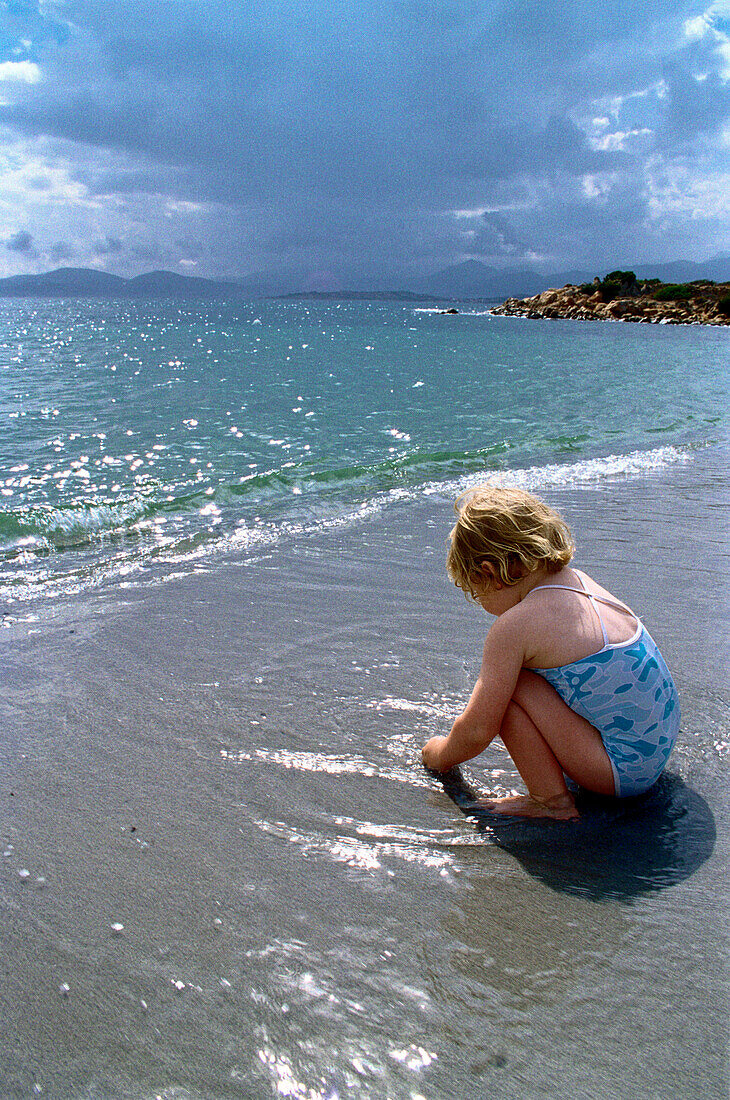 Spielendes Kind am Wasserrand, Sardinien, Italien
