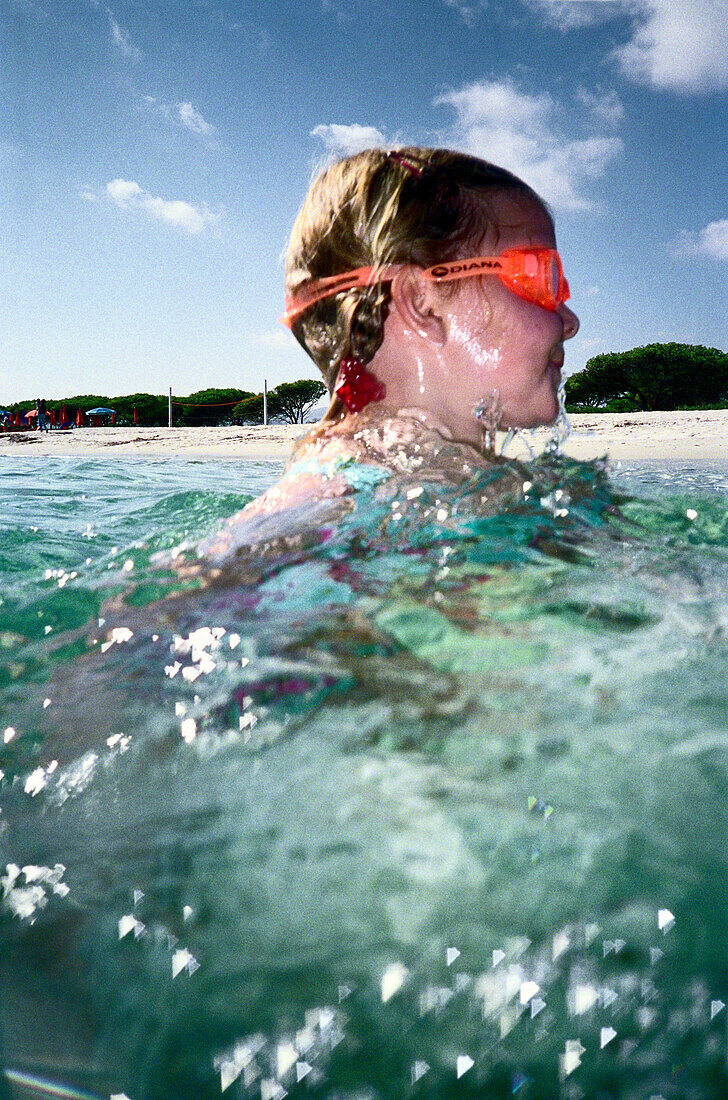 Child swimming in the sea, Sardinia, Italy