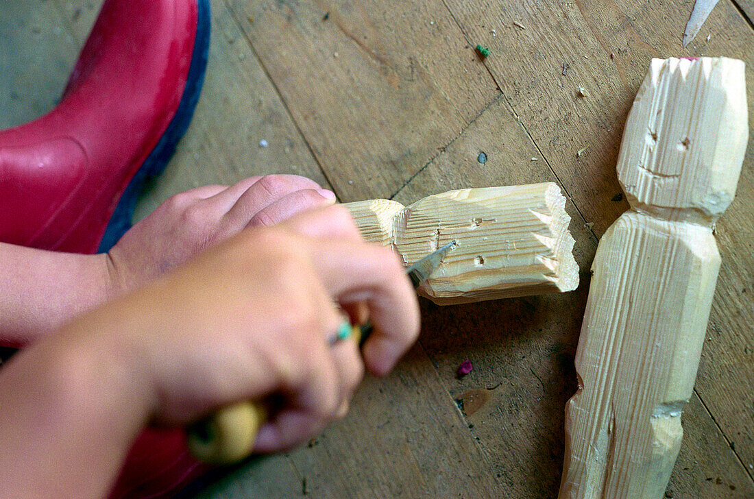Child carving a wooden figure