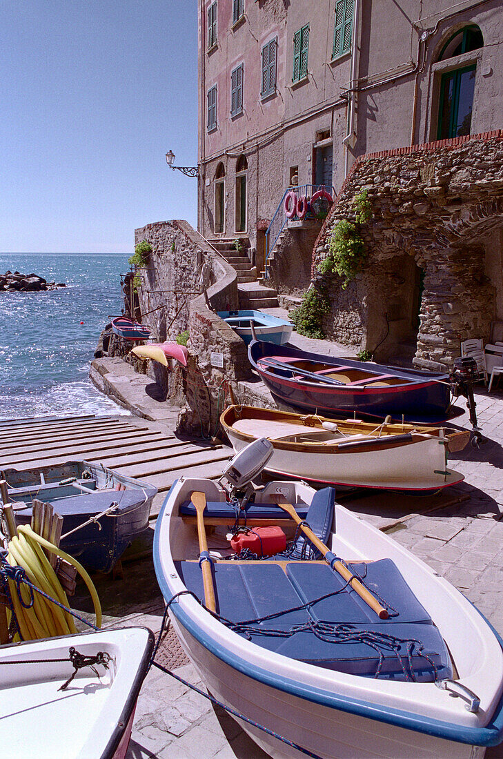 Boote im Sonnenlicht vor Häusern der Altstadt, Riomaggiore, Cinque Terre, Ligurien, Italien, Europa