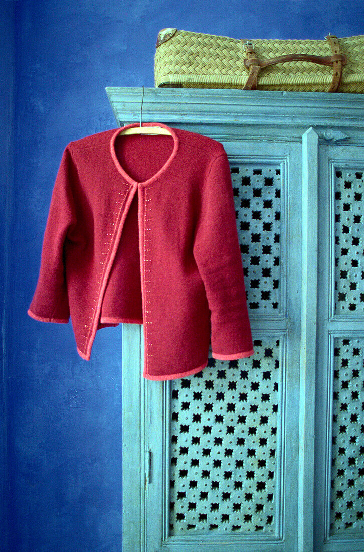 Interior view of a hotel room, red jacket hanging on a blue cupboard, Drome, France