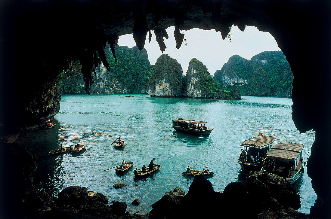 People in boats in front of a grotto, Ha-Long bay, Vietnam, Asia