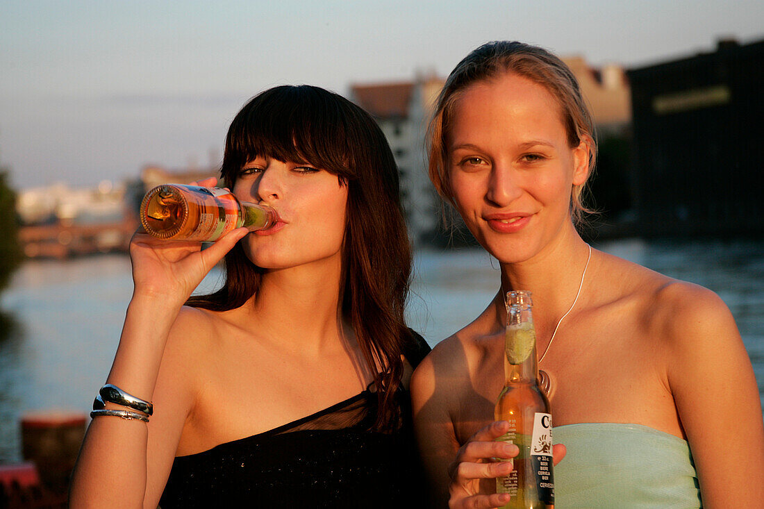 Zwei junge Frauen bei einer Strandbar an der Spree, bei Oberbaumbrücke, Berlin, Deutschland