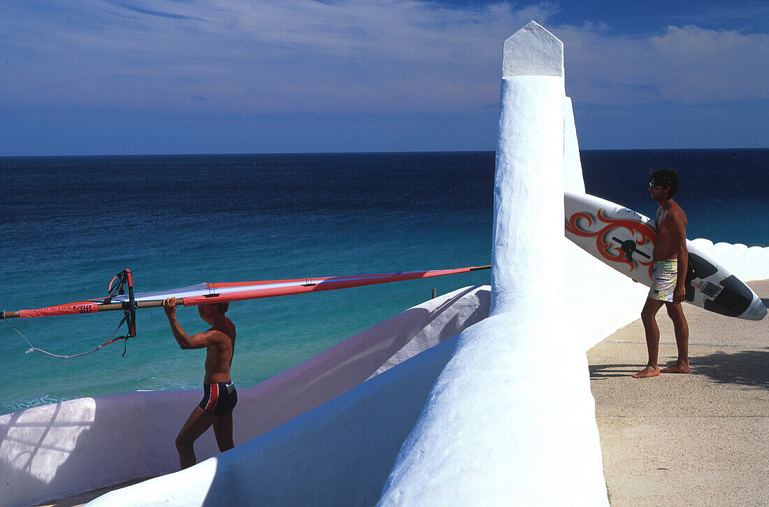 Männer tragen Surfbretter zum Meer, Sotavento de Jandia, Fuerteventura, Spanien, Europa