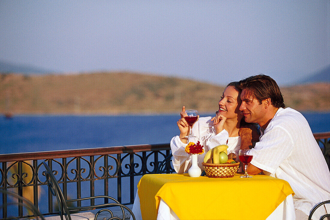 Ein verliebtes Paar trinkt Wein auf der Terrasse in einem Restaurant
