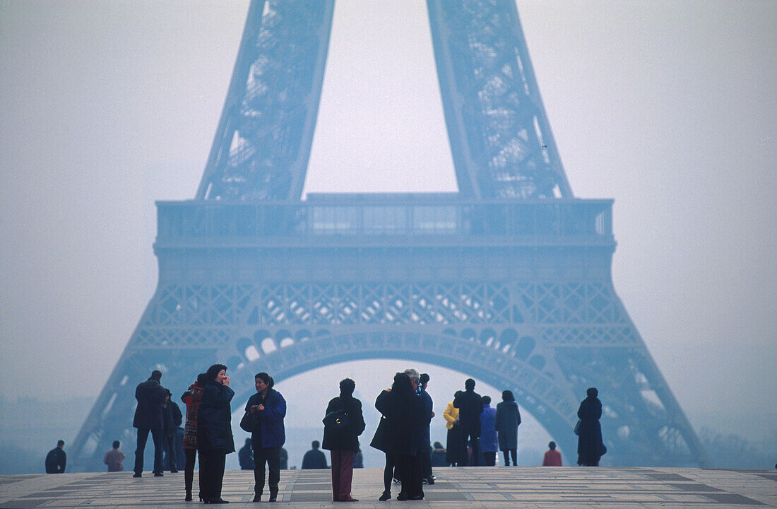 People in the fog in front of the Eiffel tower, Paris, France, Europe