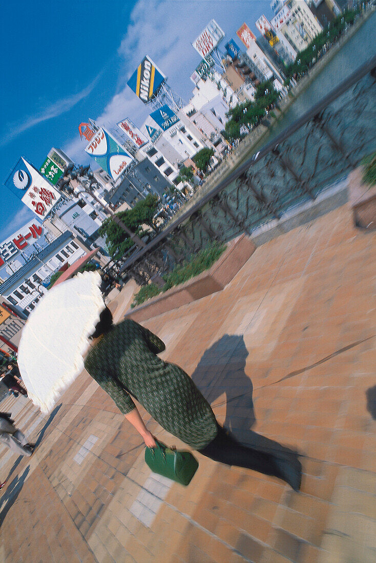 Frau mit Sonnenschirm vor Häuser mit Reklame, Tokio, Japan, Asien