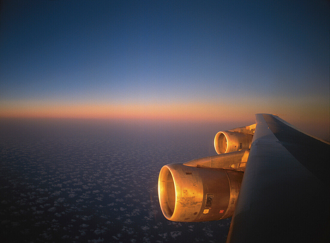 Engine in the warm sunlight from below just before sunset obove small clouds over Arabia