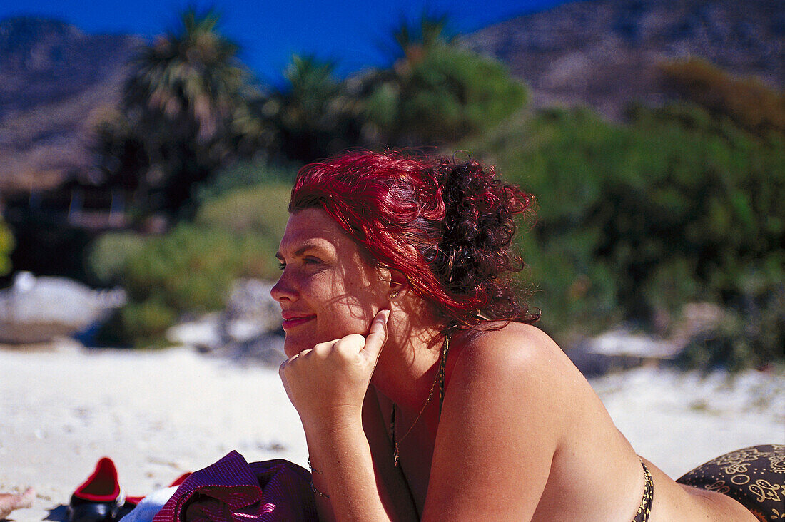 Woman sunbathing on Boulders Beach, Cape Town, South Africa, Africa