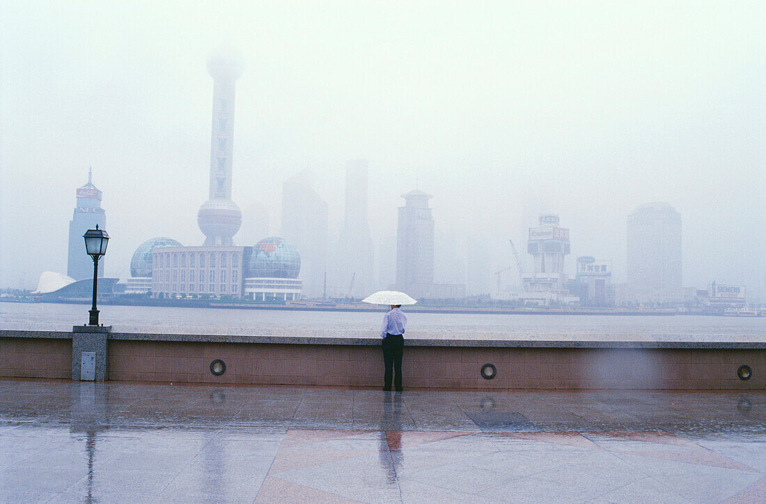 Lonesome pedestrian looking over the Huangpu River at Pudong, Shanghai, China