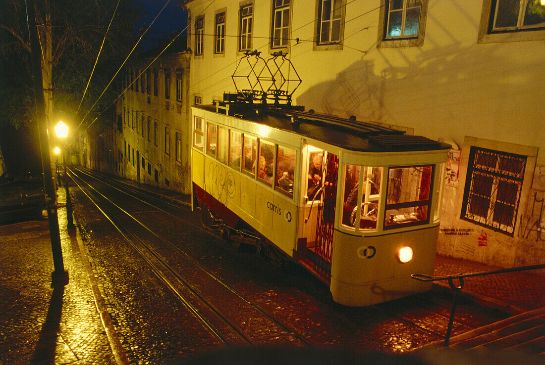 A streetcar going up a steep street at night, Elevador de Santa Justa, Lisbon, Portugal