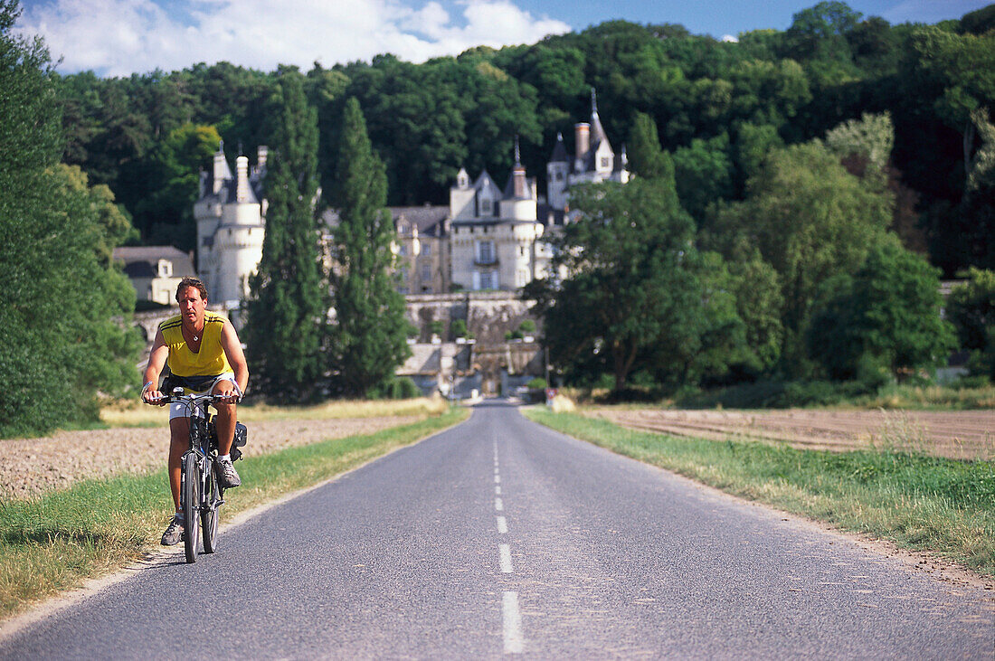 Man riding a mountainbike, Chateau d´ Ussé in the backround, Loire Valley, France