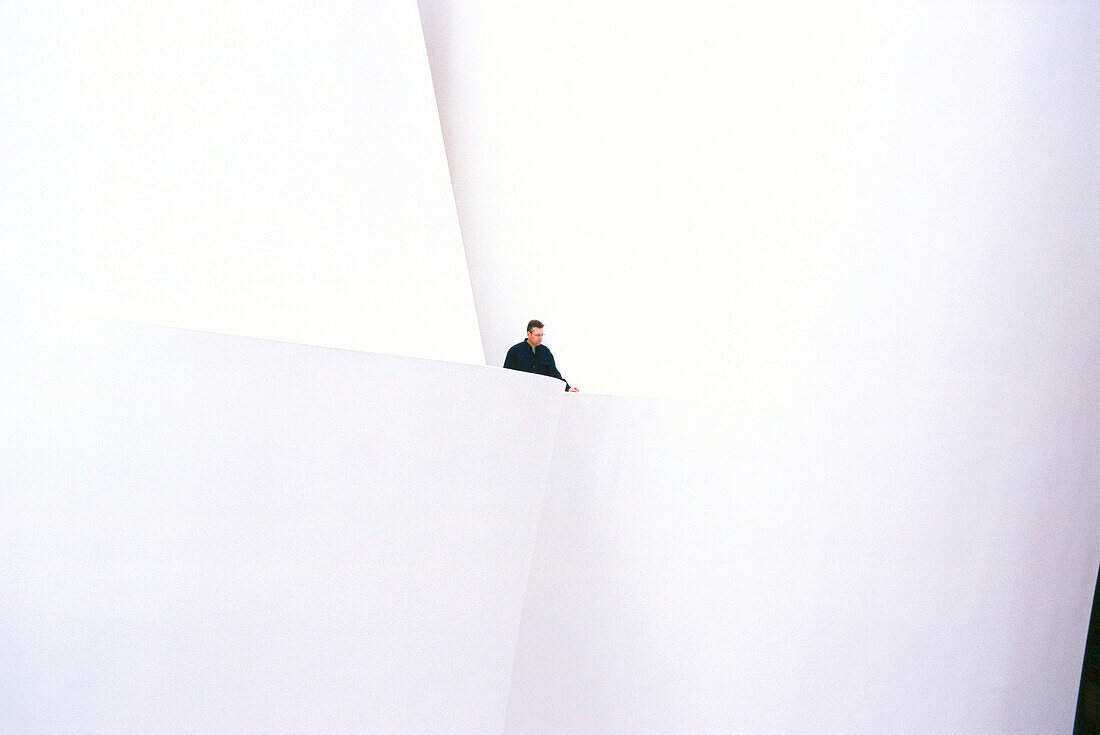 A man at the bright foyer of the Guggenheim Museum, Bilbao, Spain