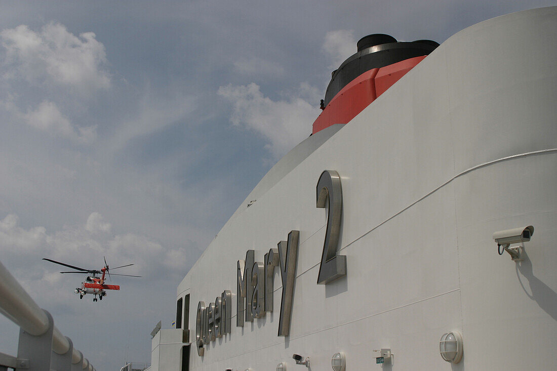 Queen Mary 2, Salvage, US coastguard helicopter, Queen Mary 2, QM2 Ein Hubschrauber der US Coastguard bei der Bergung eines verletzten Besatzungsmitglieds vor der amerikanischen Atlantikkueste.