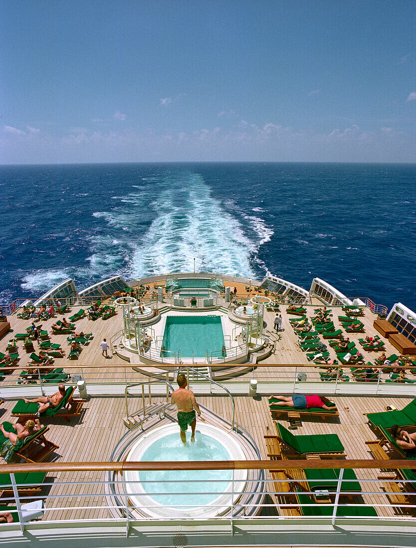 People sunbathing on quarterdeck of the cruise ship Queen Mary 2