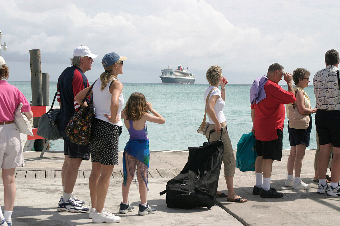 Queen Mary 2, Passengers on a pier, St. Maarten, Queen Mary 2, QM2 Vor Anker liegend vor der Küste von St.Maarten in der Karibik. Passagiere warten auf Boote für den Rücktransport zum Schiff. Buch S. 133
