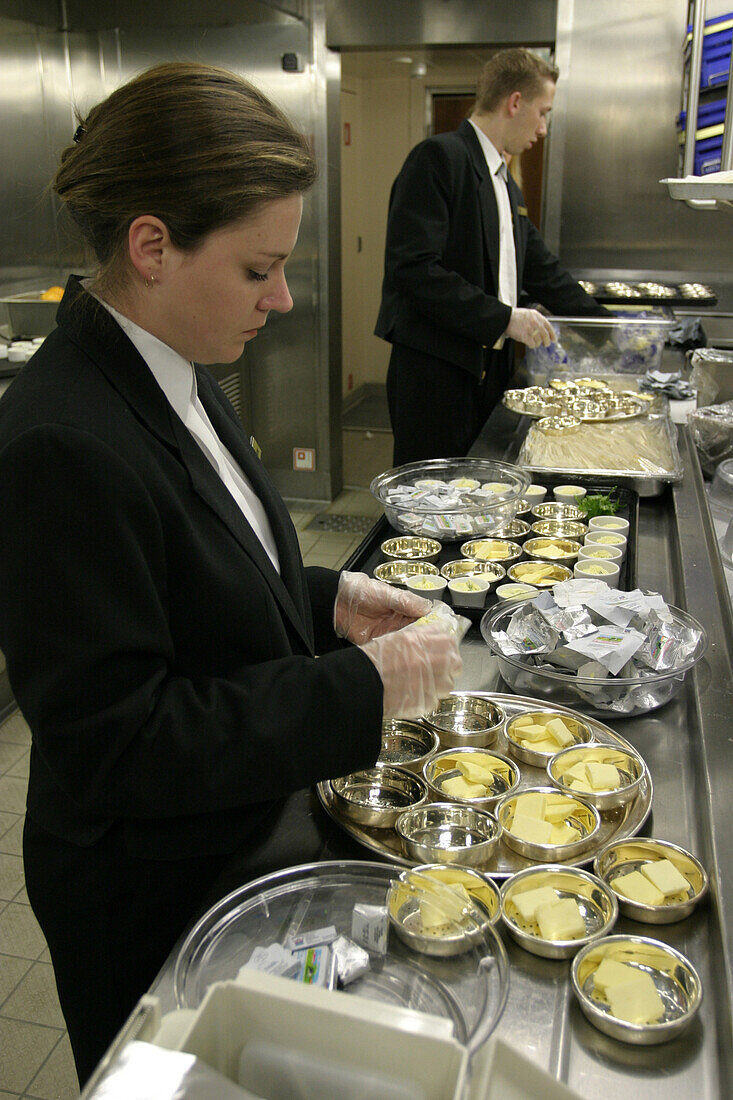 Queen Mary 2, Waiter, Canteen kitchen, Queen Mary 2, QM2 Kellner beim Auspacken von Butterstücken in der Hauptküche.