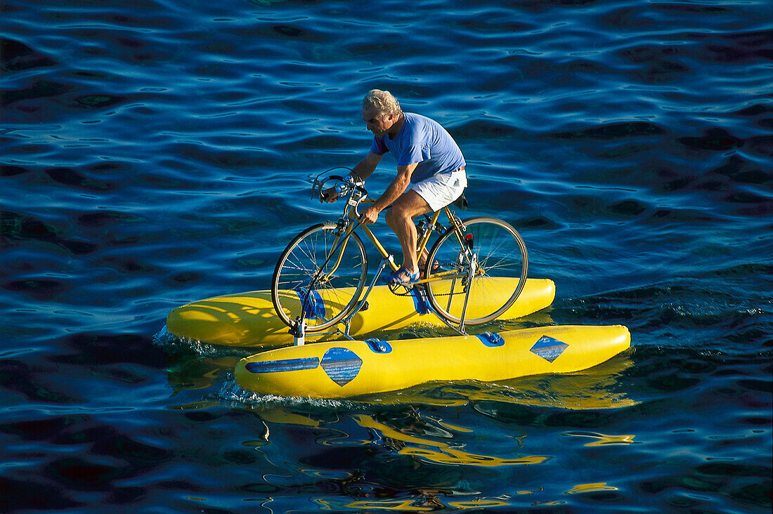 Mann auf einem Fahrrad im Wasser, Sta. Maria de Leuca, Lecce, Apulien, Italien, Europa