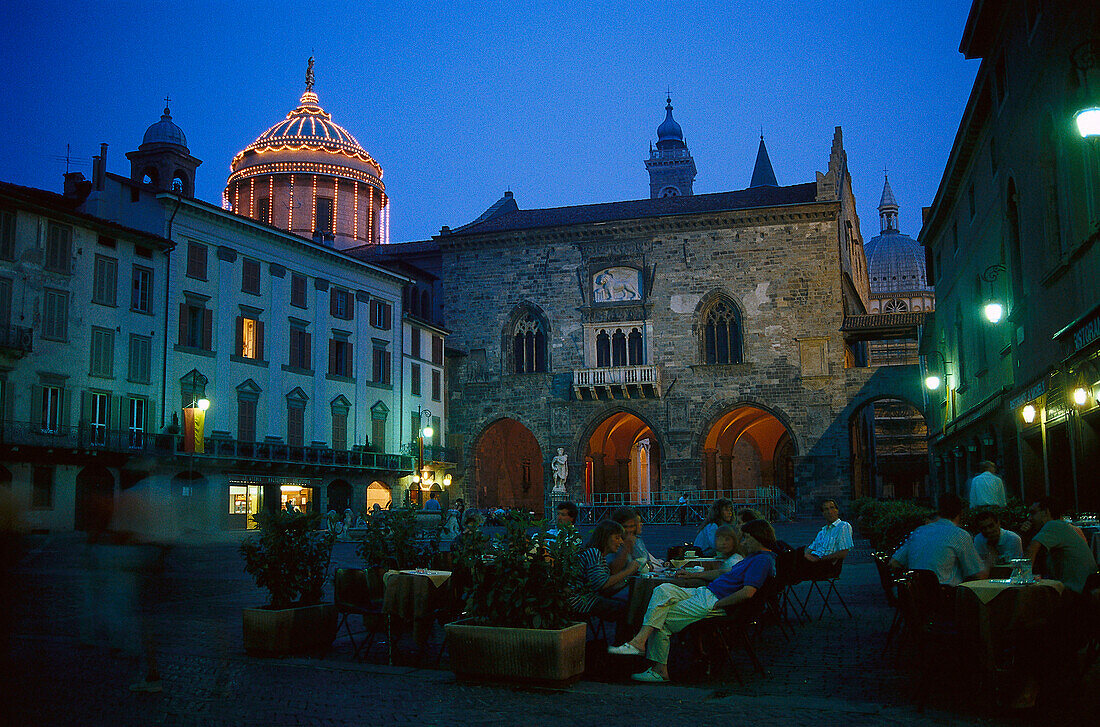 Menschen sitzen abends in einem Strassencafe auf der Piazza Vecchia, Bergamo, Lombardei, Italien, Europa