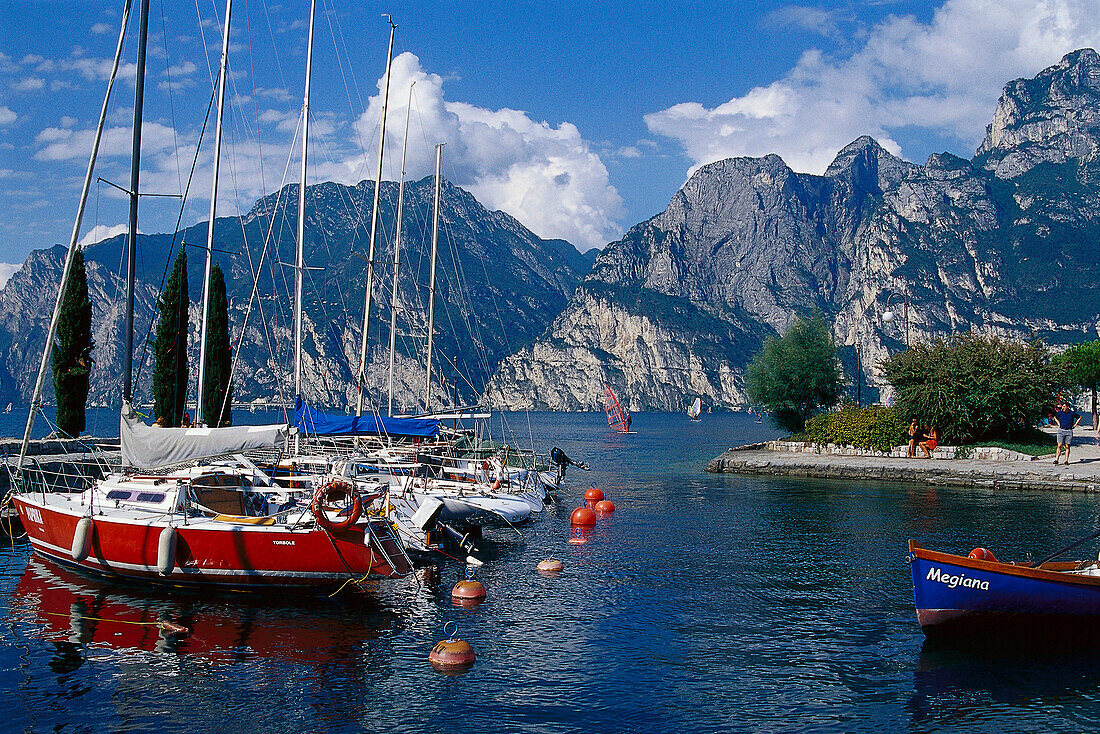 Segelboot ankern auf dem See vor Bergen im Sonnenlicht, Torbole, Gardasee, Trentino, Italien, Europa