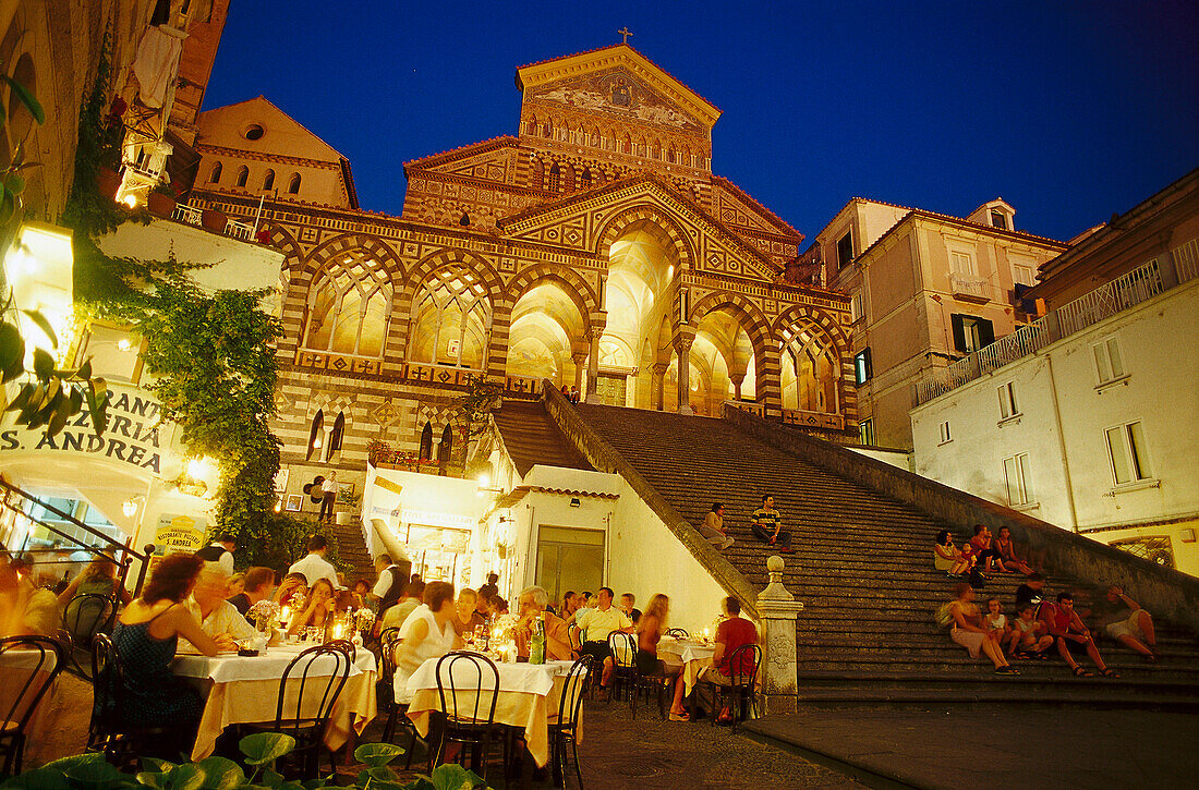 Menschen sitzen abends vor einem Restaurant und auf der Treppe vor dem Dom San Andrea, Piazza del Duomo, Amalfi, Amalfitana, Campagnia Italy, Italien, Europa
