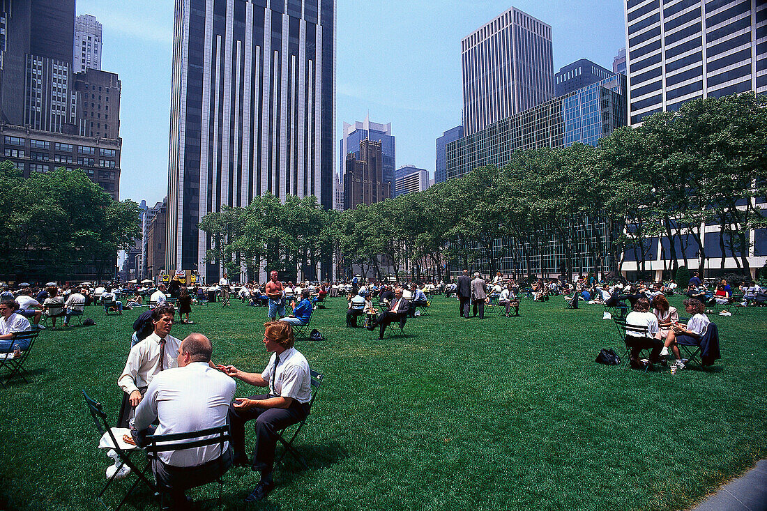 Menschen auf einer Wiese im Bryant Park, 6th Avenue, Theater District, Manhattan, New York, USA, Amerika