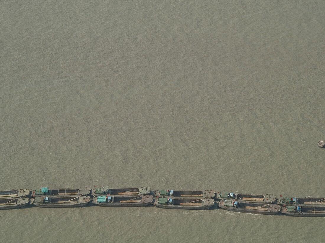 A line of boats on a muddy river, Shanghai, China