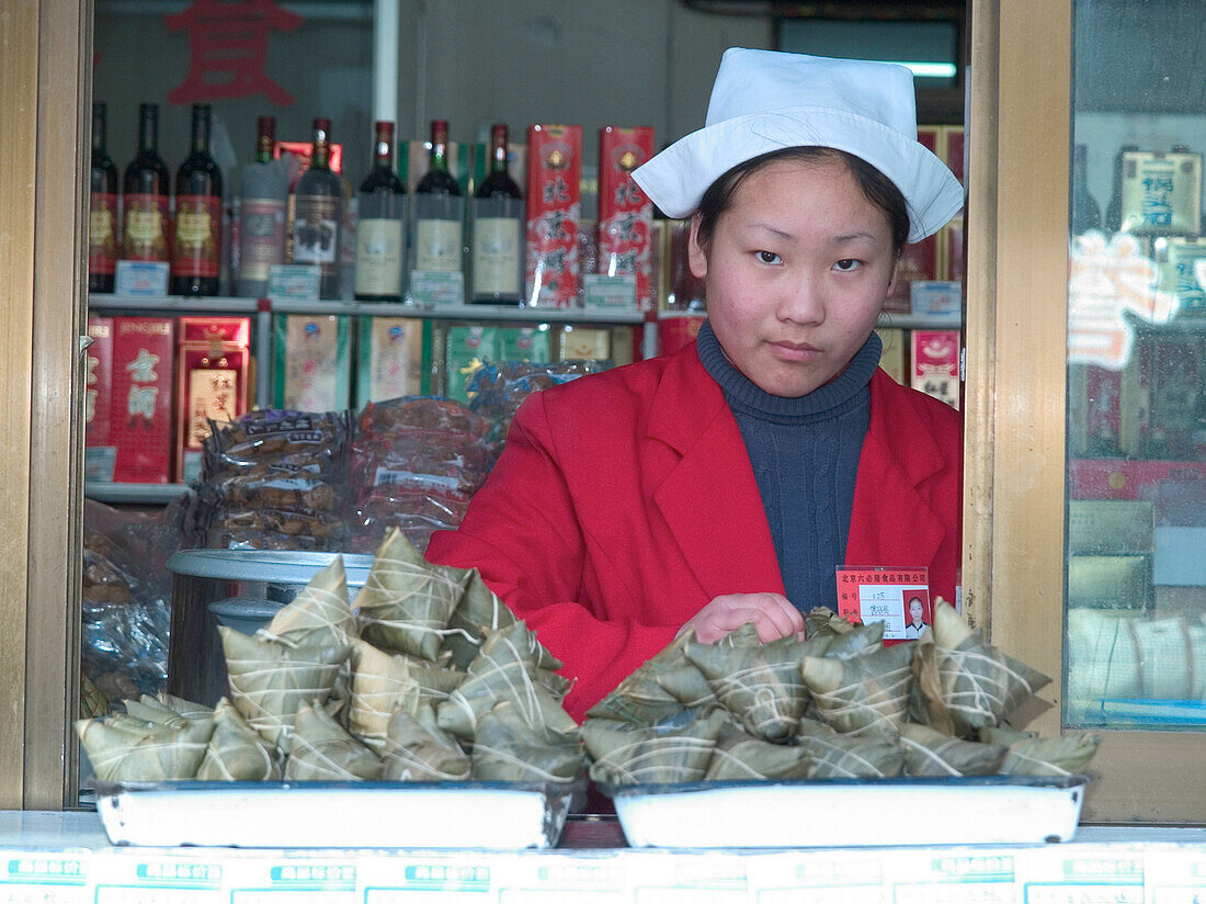 Woman selling food in a street shop, Shanghai, China