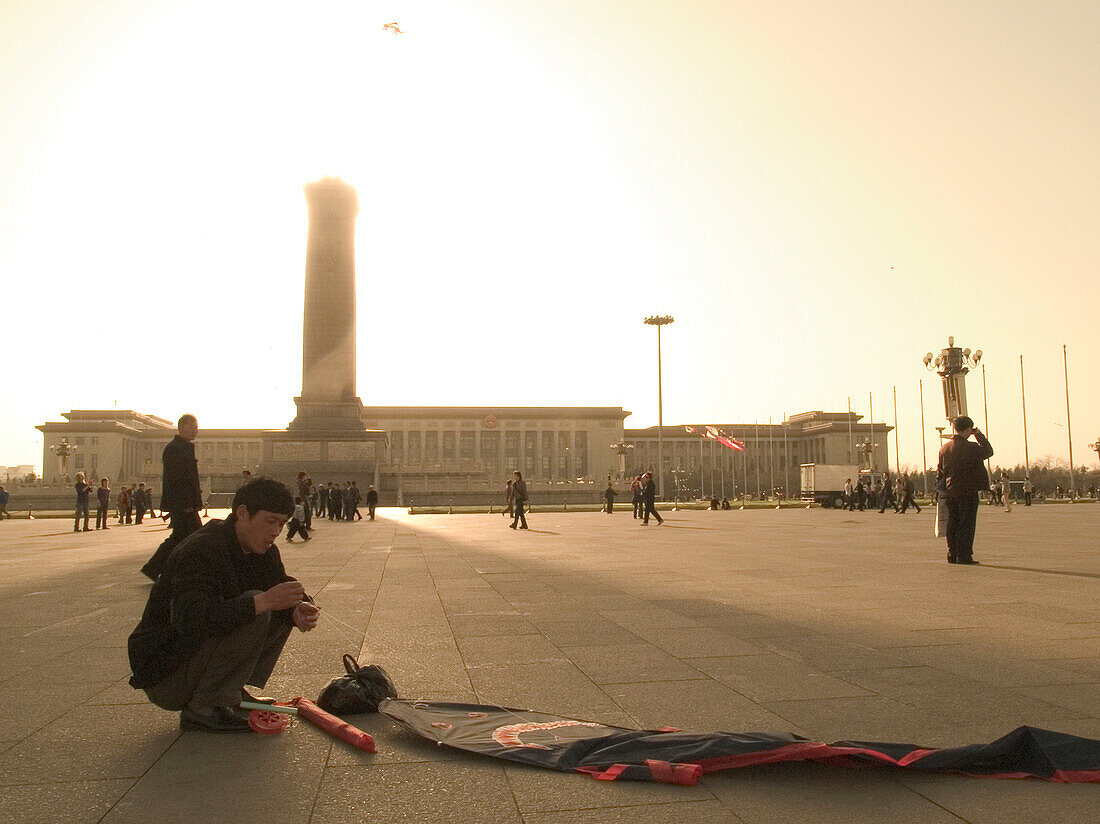 Man with kite cowering on Tiananmen Square, Peking, China, Asia