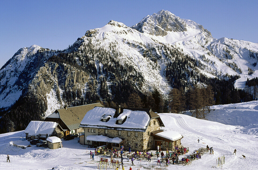 Menschen vor einer Berghütte im Sonnenlicht, Karnische Alpen, Berner Oberland, Schweiz