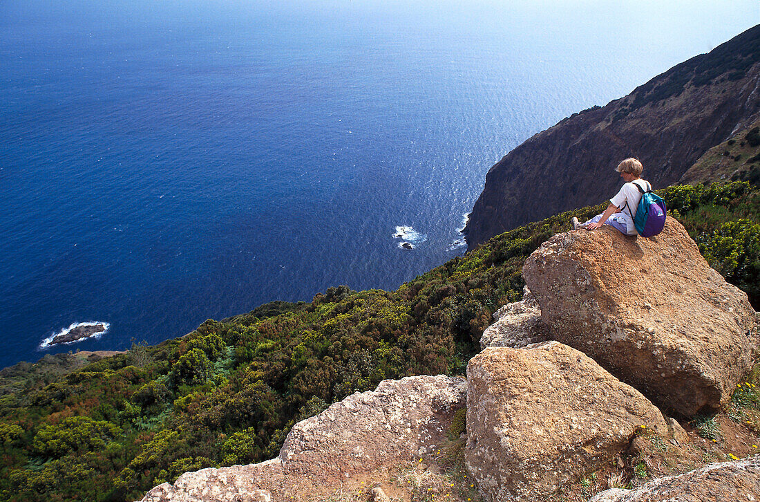 Frau sitzt auf Felsen, Wandern, Nordküste, Madeira, Portugal