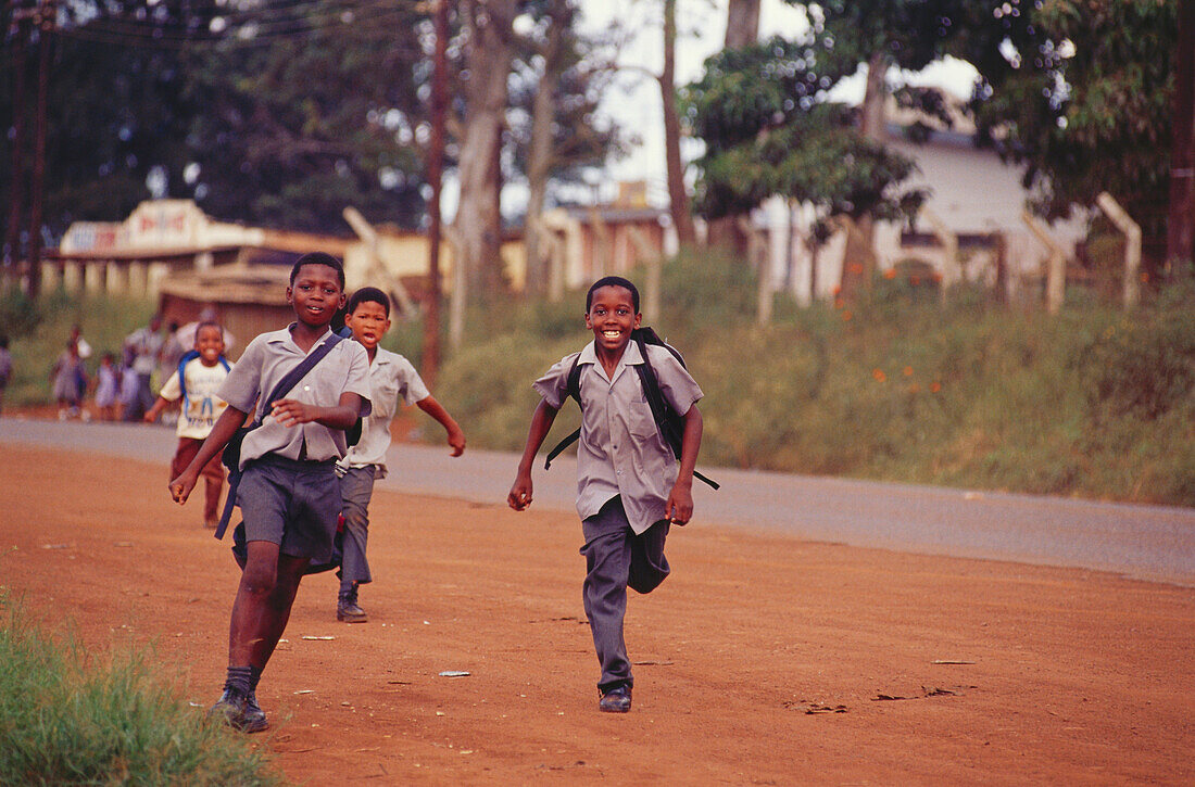 Pupils running along the street, Lebombo Mountains, Swaziland, South Africa, Africa